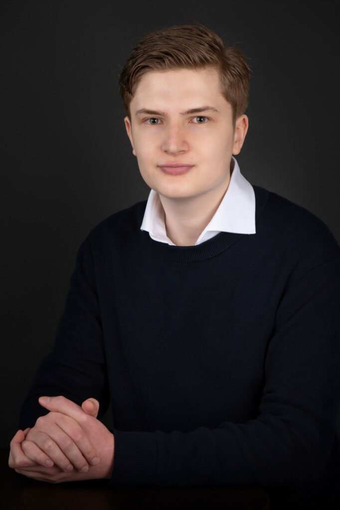 Photo CV d'un jeune homme appuyé contre une table haute