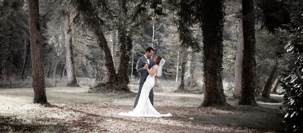 Mariés dans un sous bois avec une pose romantique